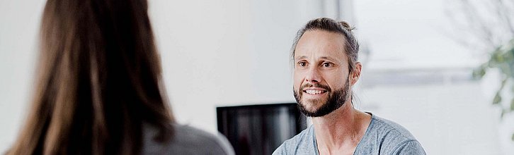 Ein Mann in einer Gesprächssituation mit einer Frau.